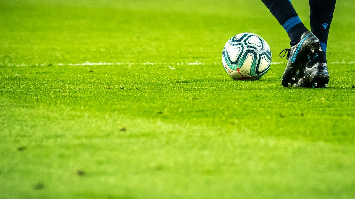 A player's boots and the ball on the pitch